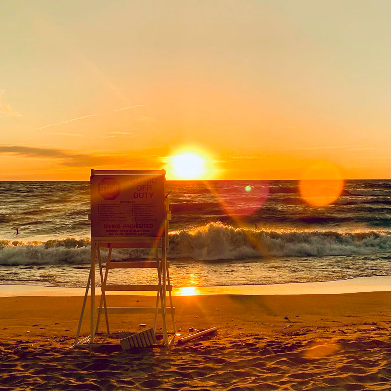 A lifeguard stand on the beach at sunset.